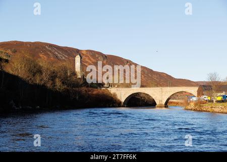 Helmsdale, Écosse. Un pont en pierre à double arc traverse la rivière Helmsdale dans la ville de Helmsdale sur la côte est. La tour est un mémorial de guerre. Banque D'Images