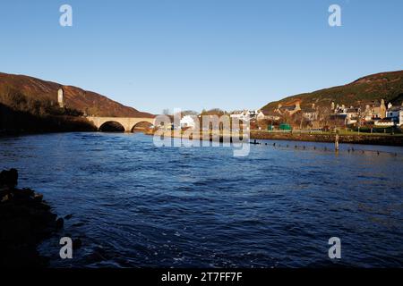 Helmsdale, Écosse. Un pont en pierre à double arc traverse la rivière Helmsdale dans la ville de Helmsdale sur la côte est. La tour est un mémorial de guerre. Banque D'Images