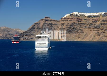 Virgin Voyages 'Resilient Lady' et MSC Cruises 'MSC Muscia' navires de croisière de luxe sous les falaises de Santorin, les îles des Cyclades, la mer Égée, Grèce. Banque D'Images