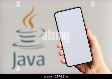 New York, USA - 15 novembre 2023 : création d'une nouvelle application mobile sur fond de plate-forme Java avec écran propre smartphone en main Banque D'Images