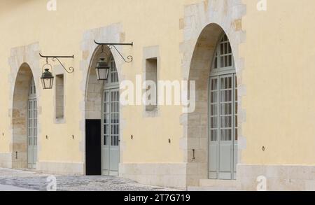 Rangée de trois portes arquées avec des fenêtres dans les portes et des lampes donnant à l'extérieur Banque D'Images