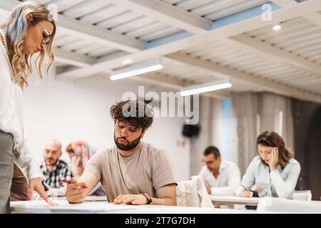 Les gens d'affaires écoutent attentivement et participent à la discussion sur le projet, posent des questions et offrent leurs commentaires et suggestions. Banque D'Images