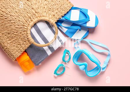 Sac femelle avec accessoires de plage et bouteille de crème solaire sur fond de couleur Banque D'Images