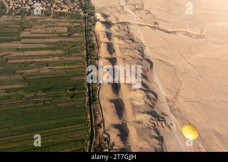 Vue aérienne de la montgolfière au-dessus de la rangée de tombeau pyramidal antique reste sur le bord du désert et des champs fertiles de la vallée du Nil Banque D'Images