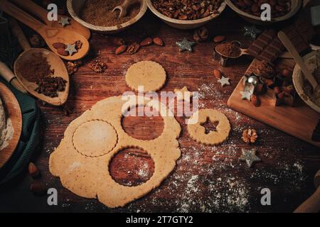 Pâte roulée, découpe de biscuits de Noël, ingrédients de cuisson, décorations de Noël, farine, sucre, amandes, noix, cannelle, emporte-pièces Banque D'Images