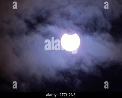 éclipse solaire partielle par la lune avec des nuages devant le soleil. Photographié à Beeville, Texas, le 14 octobre 2023. Banque D'Images