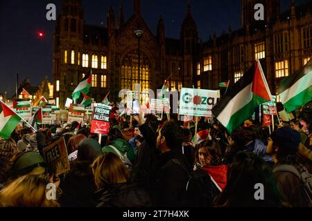 Londres, Royaume-Uni. 15 novembre 2023. Des manifestants sont vus brandissant des pancartes et des drapeaux palestiniens alors qu'ils manifestaient devant le Parlement britannique à Westminster. Les partisans pro-palestiniens se rassemblent devant la place du Parlement ce soir alors que les membres du Parlement votent sur l'amendement du cessez-le-feu du discours du roi proposé par le Parti national écossais (SNP). Ils exigent un cessez-le-feu immédiat et l'arrêt des bombardements superficiels et des assassinats innocents de Palestiniens piégés à Gaza par les forces israéliennes. Crédit : SOPA Images Limited/Alamy Live News Banque D'Images