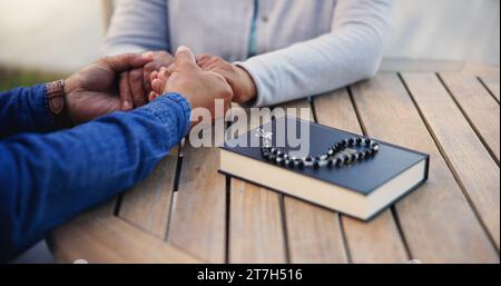 Bible, prière ou couple tenant la main sur la table ensemble dans une croyance chrétienne avec espoir ou foi. Jésus, zoom ou homme âgé avec femme dans la prière à Banque D'Images