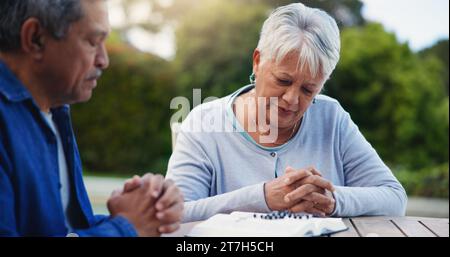 Vieux couple et prier à la bible pour la foi religieuse ou dieu espoir ou louange de l'esprit Saint, étudier pour l'adoration. Senior, les gens et les mains pour la lecture de soutien ou Banque D'Images