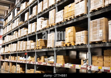 Rangées d'étagères avec des boîtes dans l'entrepôt d'usine. Intérieur de l'entrepôt. Rangées d'étagères avec boîtes. Banque D'Images