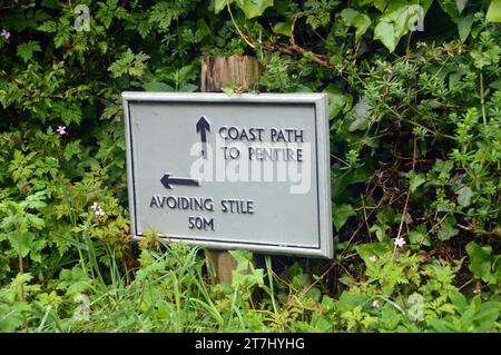 Panneau en bois avec des flèches pointant vers le sentier côtier Pentire sur le sentier côtier du Sud-Ouest et en évitant le Stile en Cornouailles, Angleterre, Royaume-Uni. Banque D'Images