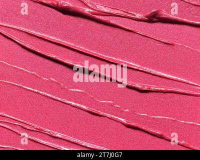 Texture chatoyante de rouge à lèvres rose, fond de texture plein cadre. Échantillon de produit cosmétique Banque D'Images