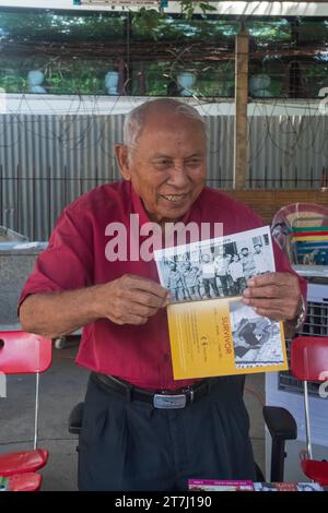 CHUM Mey et son livre dans la cour de la prison de tuol sleng à phnom penh, cambodge Banque D'Images