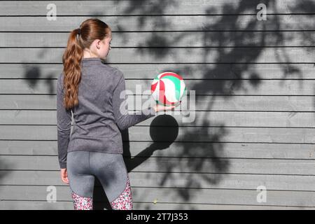 Adolescente tenant le volley-ball, tient le ballon prêt à servir Banque D'Images