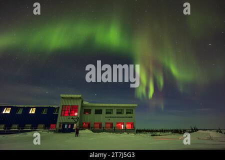 Rideaux auroraux dans le nord au-dessus du Churchill Northern Studies Centre, avec un photographe solitaire installé. C'était le 25 février 2023 à partir du par Banque D'Images