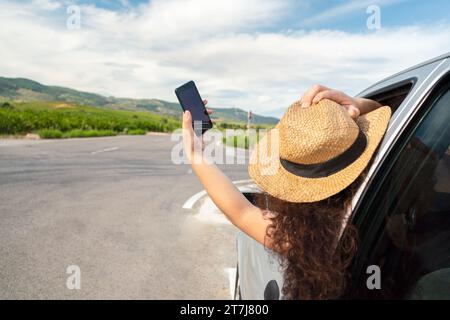 Main avec un smartphone recherchant le signal d'une voiture sur une autoroute Banque D'Images