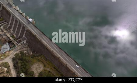 Vue aérienne du mur du barrage de Bellus à Valence, Espagne avec la route qui le traverse et les eaux calmes du réservoir. Concept de paysage Banque D'Images