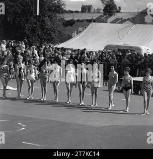 Années 1960, historiques, concurrentes féminines dans un line-up de compétition de reine de beauté dehors dans leurs maillots de bain, Angleterre, Royaume-Uni. Banque D'Images