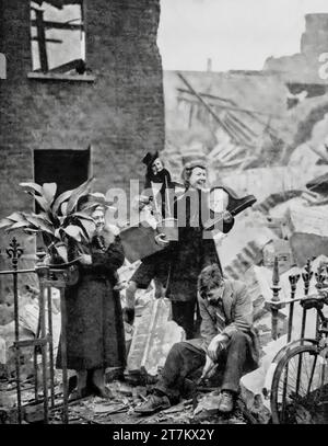 Malgré des nuits blanches pendant la Seconde Guerre mondiale dans des abris anti-aériens, les Londoniens parviennent toujours à sourire après avoir sauvé une horloge et une aspiration de leur maison récemment bombardée, Londres, Angleterre, octobre 1940. Banque D'Images