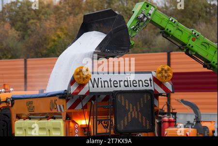 Chemnitz, Allemagne. 16 novembre 2023. Un véhicule de grenaillage du dépôt de maintenance de l'autoroute de Chemnitz est chargé de sel. Les dépôts d'entretien des autoroutes de la Saxe sont bien préparés pour l'hiver à venir. Pour maintenir la circulation sur les plus de 500 kilomètres d'autoroute dans le gel et la neige, 64 véhicules et un bon 230 employés sont en attente. Cela comprend également un stock de plus de 15 000 tonnes de sel de voirie. Crédit : Hendrik Schmidt/dpa/Alamy Live News Banque D'Images