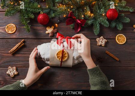 Stollen de Noël avec massepain et fruits secs sur fond sombre. Lumière de Noël festive, ambiance de vacances, temps joyeux Banque D'Images