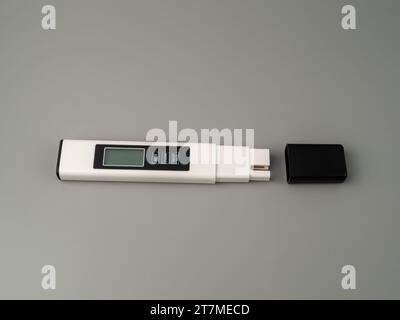 Testeur de qualité de l'eau sur fond gris. Dispositif pour mesurer la qualité de l'eau. Banque D'Images