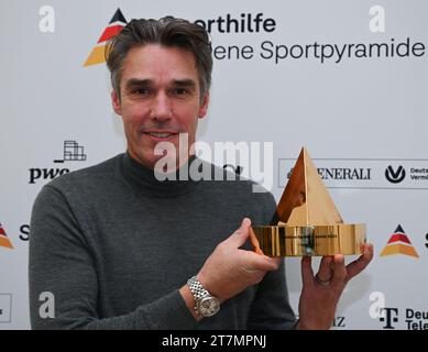 Neu Isenburg, Allemagne. 16 novembre 2023. Michael Stich, ancien joueur de tennis et champion olympique, tient la « Pyramide sportive d'or » lors d'un événement de presse organisé par la Fondation allemande d'aide au sport à Gravenbruch. C'est la récompense la plus précieuse dans le sport allemand. Crédit : Arne Dedert/dpa/Alamy Live News Banque D'Images