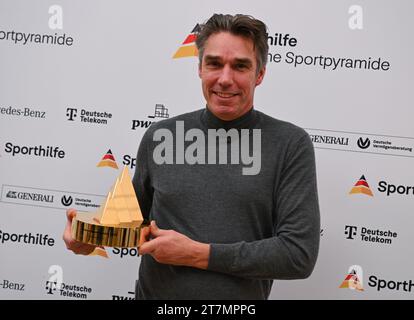 Neu Isenburg, Allemagne. 16 novembre 2023. Michael Stich, ancien joueur de tennis et champion olympique, tient la « Pyramide sportive d'or » lors d'un événement de presse organisé par la Fondation allemande d'aide au sport à Gravenbruch. C'est la récompense la plus précieuse dans le sport allemand. Crédit : Arne Dedert/dpa/Alamy Live News Banque D'Images