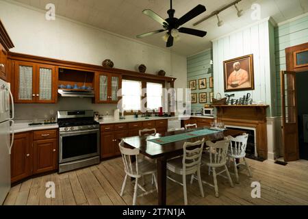 Cuisine avec table en bois sous un portrait d'une femme américaine africienne au-dessus de la cheminée à l'intérieur du B & B de T'Frere, une maison coloniale acadienne cajun 1880 Banque D'Images