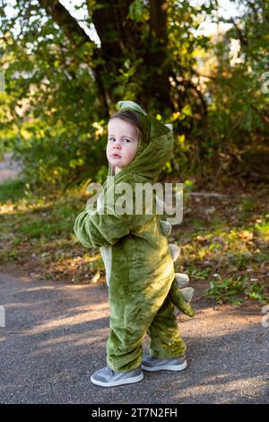 Beau petit garçon déguisé en dinosaure pour halloween dans le parc Banque D'Images