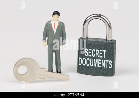 Concept commercial. Sur une surface blanche, il y a une figurine d'un homme d'affaires, une clé et une serrure avec l'inscription - documents secrets Banque D'Images