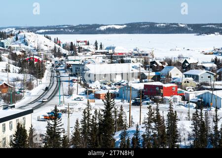 Aperçu du lac des esclaves gelé avec des péniches gelées sur la glace où les habitants vivent toute l'année accédant à leurs maisons en motoneige ou en voiture en hiver mont Banque D'Images