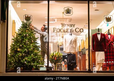 USAGE ÉDITORIAL SEULEMENT Une vue de Henry Poole & Co sur Savile Row alors que les décorations sont ajustées lors de la lumière de Noël au cœur de Mayfair. Date de la photo : jeudi 16 novembre 2023. Banque D'Images