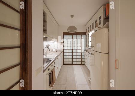 Cuisine japonaise moderne design intérieur dans des tons de terre, textures naturelles avec mobilier en bois massif en chêne et portes coulissantes en bois japonais. Conce Japandi Banque D'Images