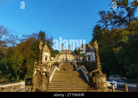 Escalier jusqu'au célèbre monastère BOM Jesus do Monte dans la lumière du soleil dorée avec des nuages sombres sur le ciel pendant l'automne à Braga, Portugal Banque D'Images