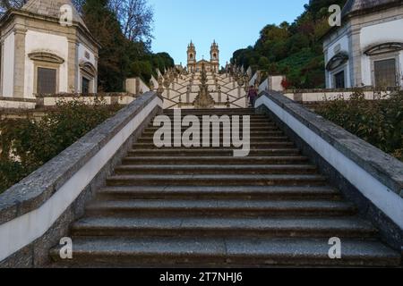 Escalier jusqu'au célèbre monastère BOM Jesus do Monte dans la lumière du soleil dorée avec des nuages sombres sur le ciel pendant l'automne à Braga, Portugal Banque D'Images