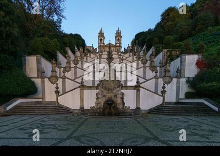 Escalier jusqu'au célèbre monastère BOM Jesus do Monte dans la lumière du soleil dorée avec des nuages sombres sur le ciel pendant l'automne à Braga, Portugal Banque D'Images