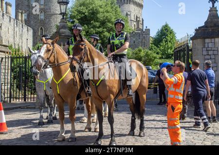 15 juin 2023 des officiers de police à cheval en service de contrôle des foules dans les rues à l'extérieur du château Royal Windsor une résidence royale officielle dans le Berkshire Englan Banque D'Images