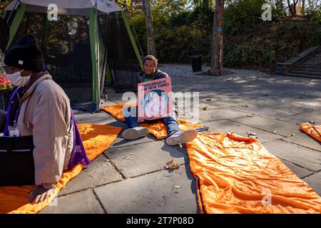 NEW YORK, NEW YORK - NOVEMBRE 16 : un manifestant assis sur un sac de couchage lors d'un rassemblement et «dormant» devant Gracie Mansion, résidence officielle du maire de New York Eric Adams, l'exhortant à cesser d'attaquer la politique du droit au logement de la ville le 16 novembre 2023 à New York. L'administration Adam a limité les séjours en refuge pour les familles immigrées et a récemment annoncé qu'elle commencerait à distribuer des tentes aux demandeurs d'asile nouvellement arrivés, au lieu d'offrir un hébergement. (Photo de Michael Nigro/Sipa USA) crédit : SIPA USA/Alamy Live News Banque D'Images