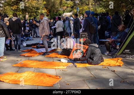 NEW YORK, NEW YORK - NOVEMBRE 16 : un manifestant assis sur un sac de couchage lors d'un rassemblement et «dormant» devant Gracie Mansion, résidence officielle du maire de New York Eric Adams, l'exhortant à cesser d'attaquer la politique du droit au logement de la ville le 16 novembre 2023 à New York. L'administration Adam a limité les séjours en refuge pour les familles immigrées et a récemment annoncé qu'elle commencerait à distribuer des tentes aux demandeurs d'asile nouvellement arrivés, au lieu d'offrir un hébergement. (Photo de Michael Nigro/Sipa USA) crédit : SIPA USA/Alamy Live News Banque D'Images