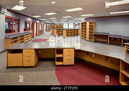 Le centre des médias et la bibliothèque dans un lycée public moderne avec bureau de checkout, étagères vides et piles. Banque D'Images