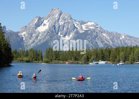 Un groupe de trois touristes flottant dans les kyaaks de mer sur le lac Jackson dans le parc national de Grand Teton, et à la base du mont Moran. Banque D'Images