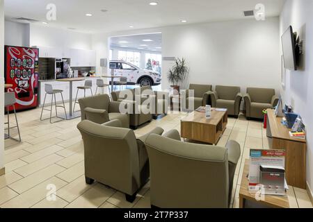 La salle d'attente des clients avec des chaises de table et des meubles confortables dans un concessionnaire automobile moderne. Banque D'Images
