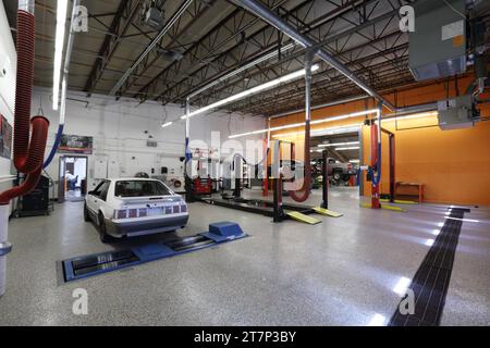 Équipement de réparation automobile industriel et voitures réparées dans un atelier automobile d'école secondaire. Banque D'Images