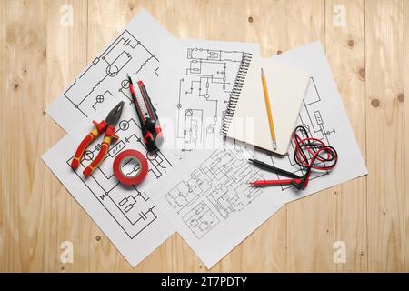 Schémas électriques, outils et papeterie de bureau sur table en bois, vue de dessus Banque D'Images