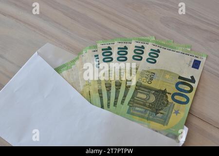 Plusieurs centaines de billets d'euros dans une enveloppe sur une table, symbolisant l'argent, la richesse ou la corruption Banque D'Images