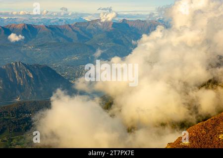 Vue aérienne sur le magnifique paysage montagneux avec des nuages et le lac de Lugano et la ville de Lugano dans une journée ensoleillée au Tessin, en Suisse Banque D'Images