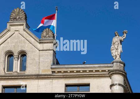 Détail du Palais Grand-Ducal, résidence du Grand-Duc de Luxembourg, avec une sculpture sur le toit de l'édifice et le drapeau luxembourgeois Banque D'Images