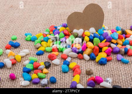 Coeur de papier au milieu des cailloux colorés sur toile sol Banque D'Images