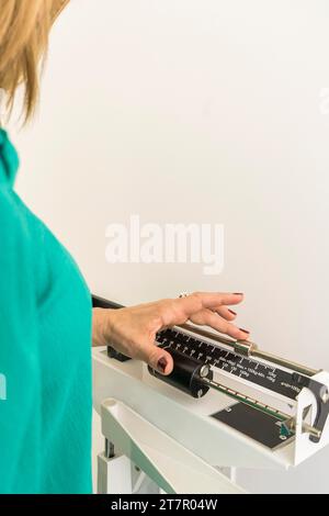 Gros plan d'une femme sur une balance dans le bureau d'un nutritionniste. Tir vertical Banque D'Images